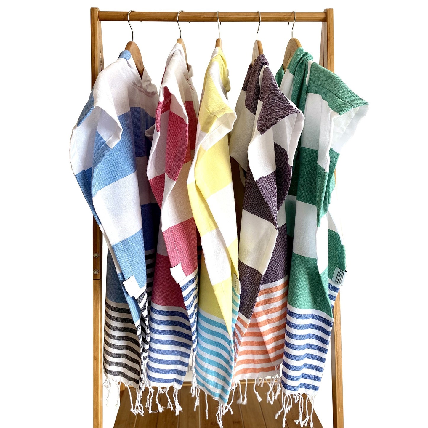 Toalla tipo poncho con diseño de rayas en morado oscuro, naranja y blanco