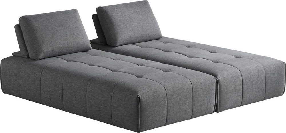 Sofá modular en forma de L de dos piezas de poliéster gris con chaise longue y cojines.