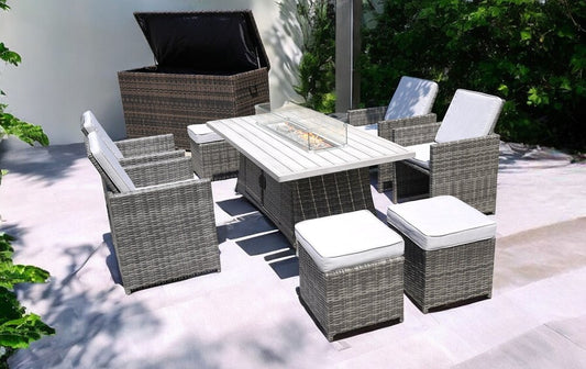 Conjunto de diez sillas de mimbre gris para exteriores con asiento para fogata y cojines blancos.