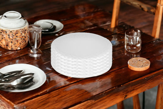 Juego de seis platos de ensalada de porcelana blanca redonda con relieve granulado.