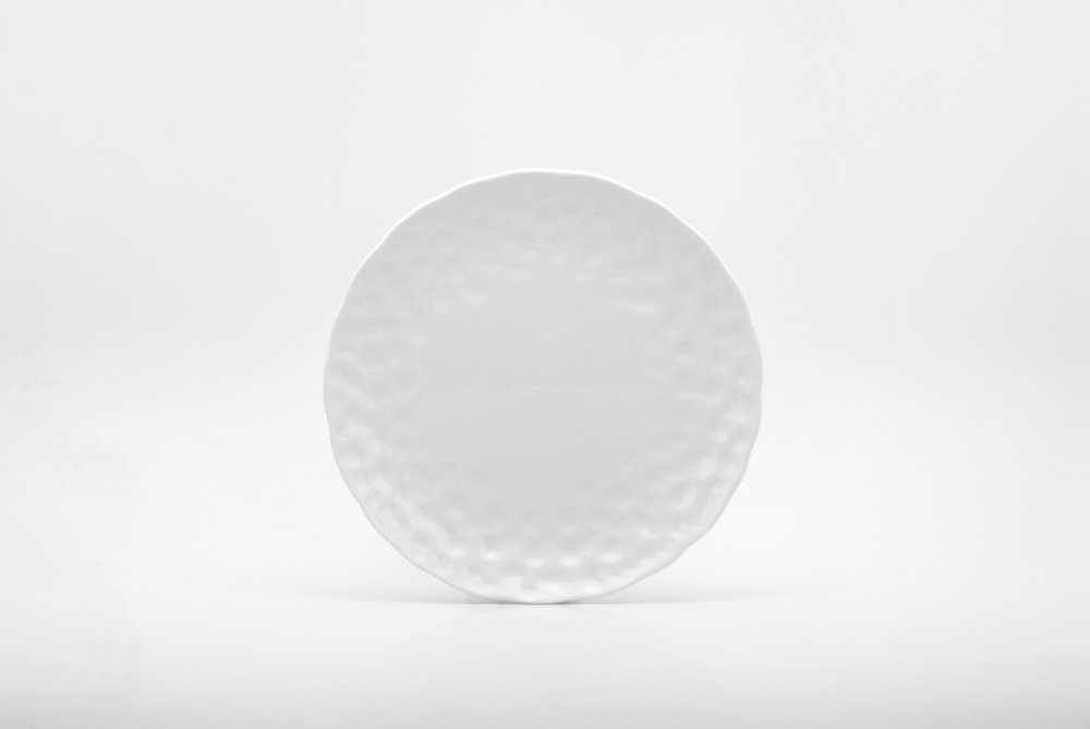 Juego de seis platos de ensalada de porcelana blanca redonda con relieve granulado.