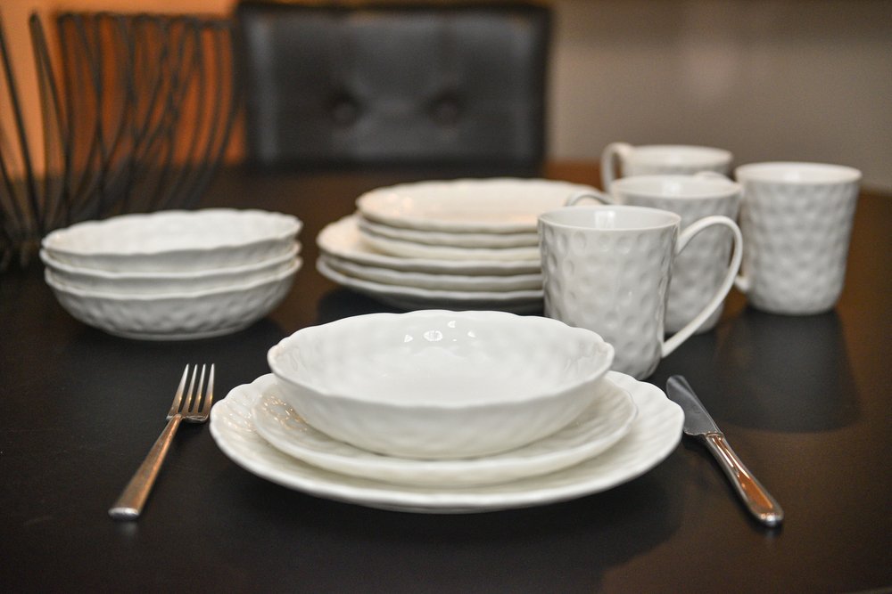 Juego de seis platos de ensalada de porcelana blanca redonda con relieve granulado.