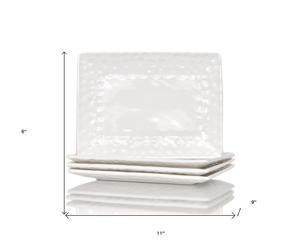 Juego de seis platos llanos de porcelana blanca con diseño de guijarros rectangulares.