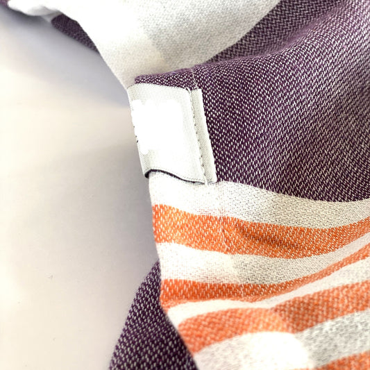Toalla tipo poncho con diseño de rayas en morado oscuro, naranja y blanco