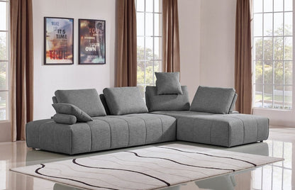 Sofá modular en forma de L de dos piezas de poliéster gris con chaise longue y cojines.