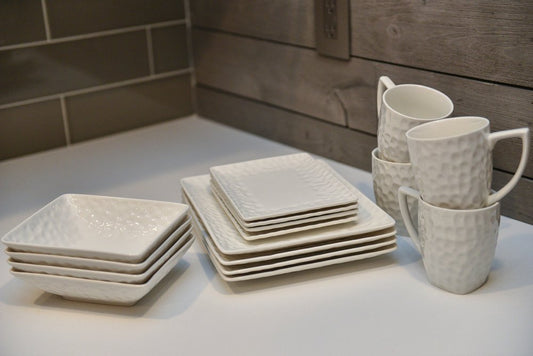Juego de seis platos llanos de porcelana blanca con diseño de guijarros rectangulares.