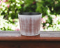 Maceta redonda de plástico reciclado de 15 cm, con textura en tonos marrones y marfil, para interior y exterior.