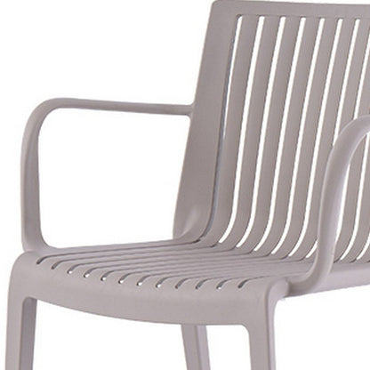 Juego de cuatro sillas apilables para exteriores de plástico resistente color topo de 22"